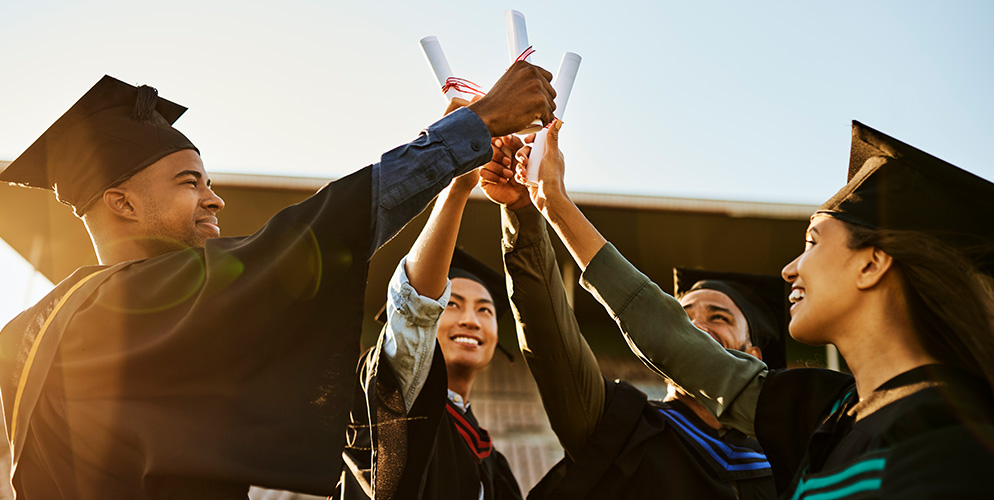 Students at graduation with diplomas